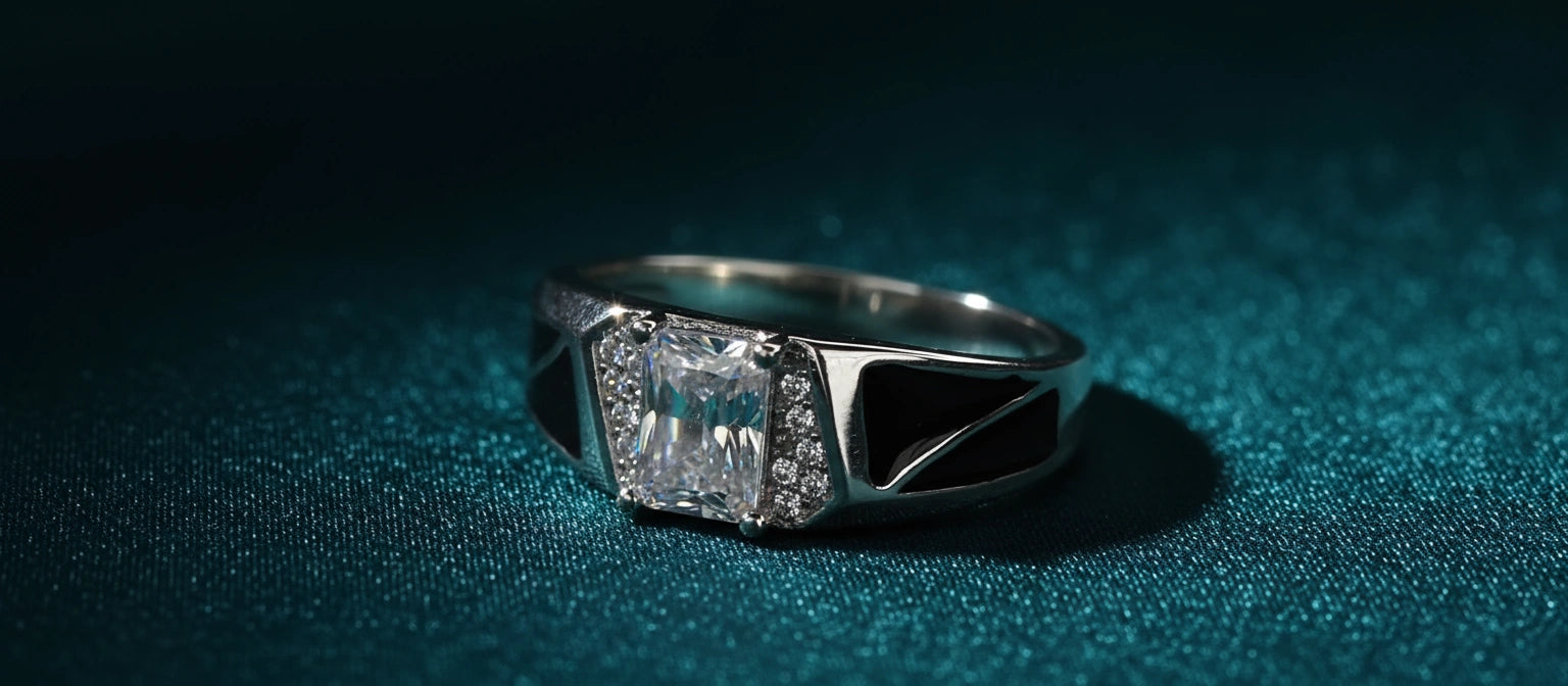 The Concord Solitaire Ring by Narayan Jewellers, a 925 silver ring with an emerald-cut stone and geometric black enamel panels, on a textured teal background.