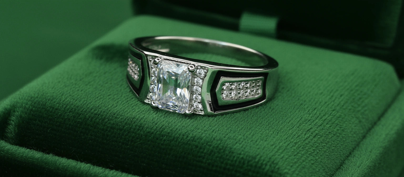 The Marquee Solitaire Ring by Narayan Jewellers, a 925 silver ring with an emerald-cut stone, black enamel, and multi-row pavé, in a green velvet ring box.